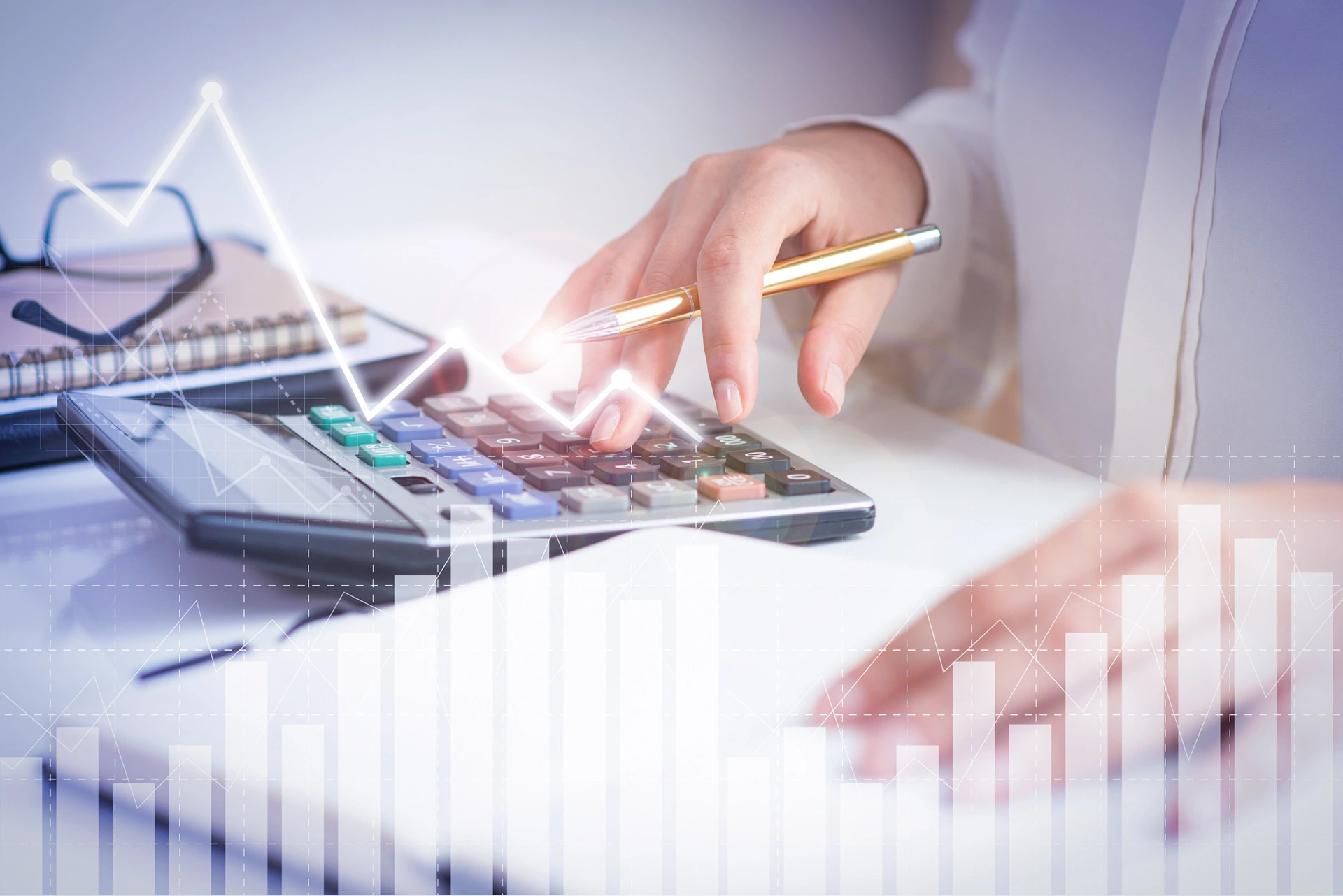 Une femme qui tape sur une calculatrice avec un stylo à la main et des graphiques en filigrane sur l'image